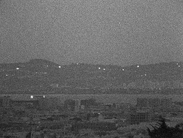 Frame showing the reflections of the setting sun in the windows of Berkeley and Oakland homes